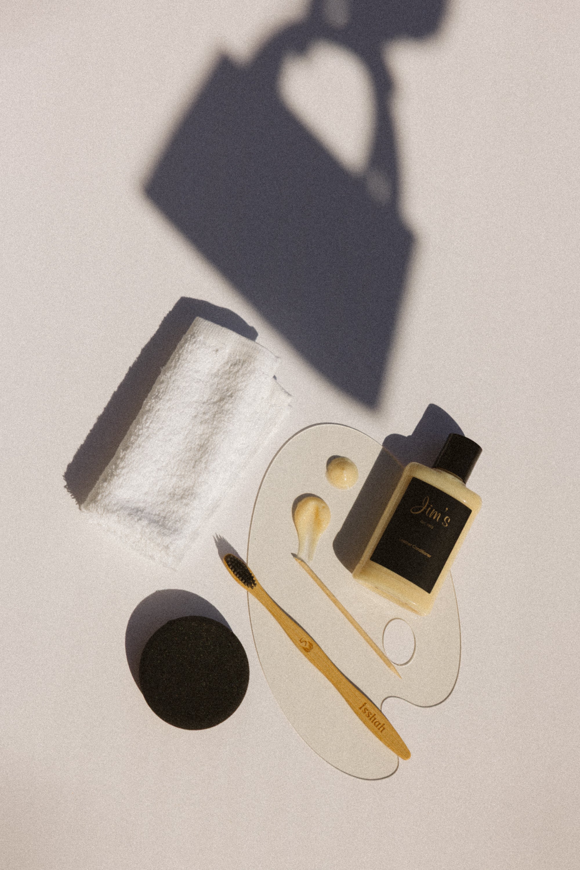 Gold and black leather cleaning tools and products on a light surface